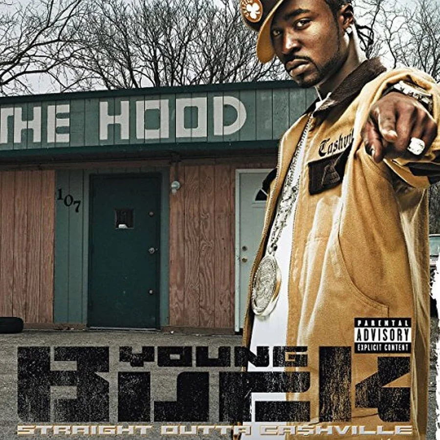 Young Buck。THE HOODの看板を背に、ジャケットとチェーンを着けた姿。