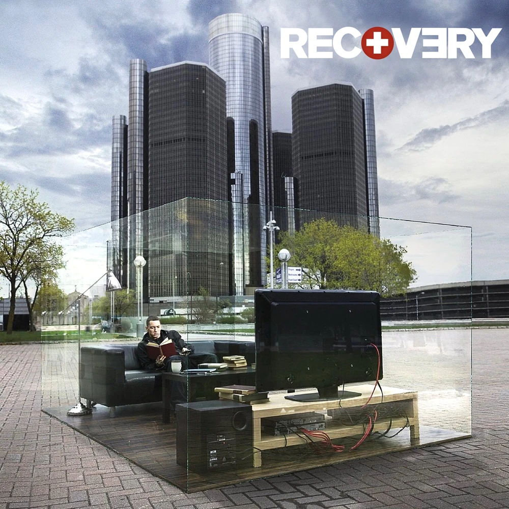 『Recovery』別ジャケット。デトロイトのビル群を背景に、透明な部屋で本を読むEminem